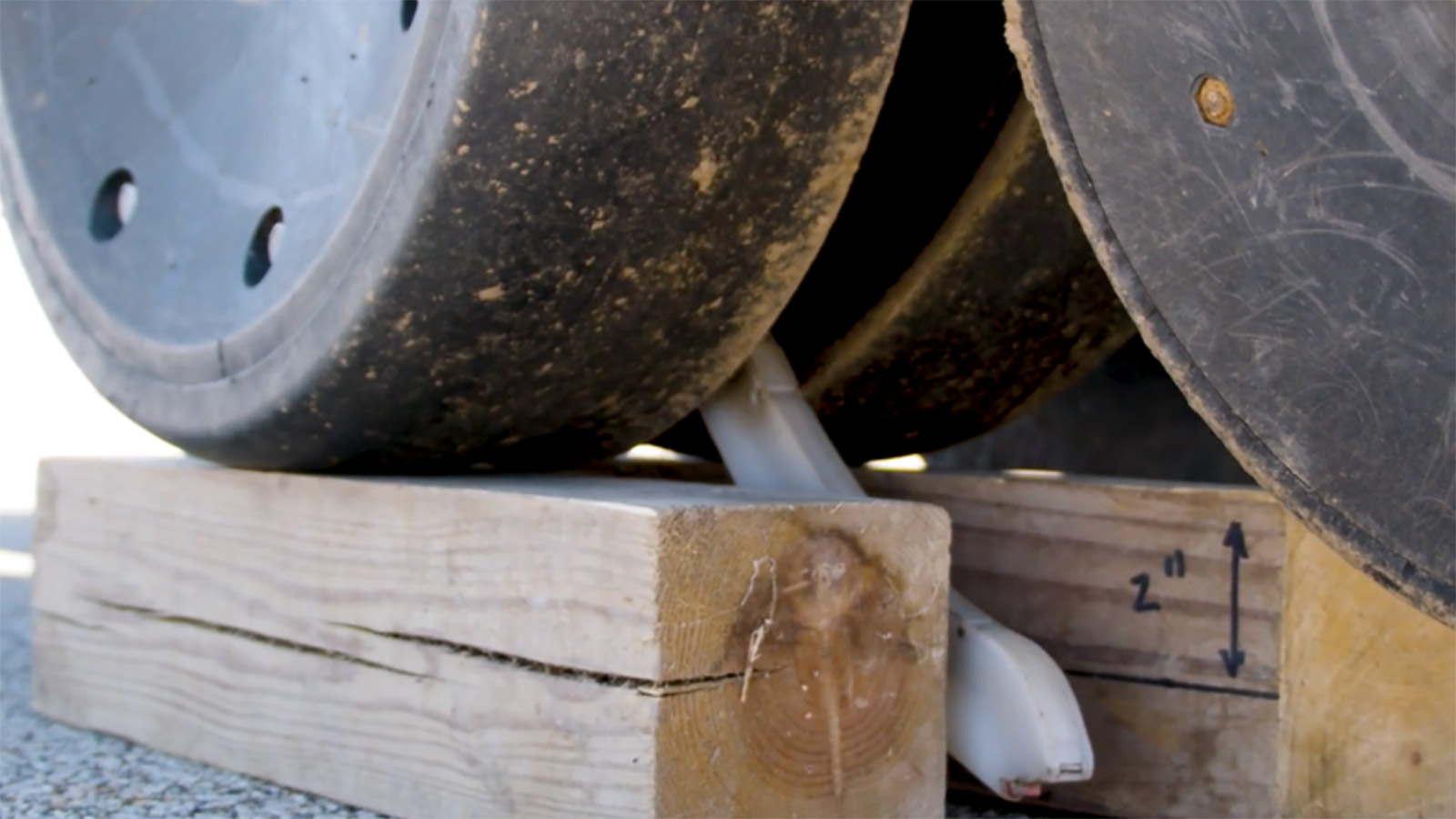 planting row unit sitting on top of a wood block showing the 2-inch depth mark