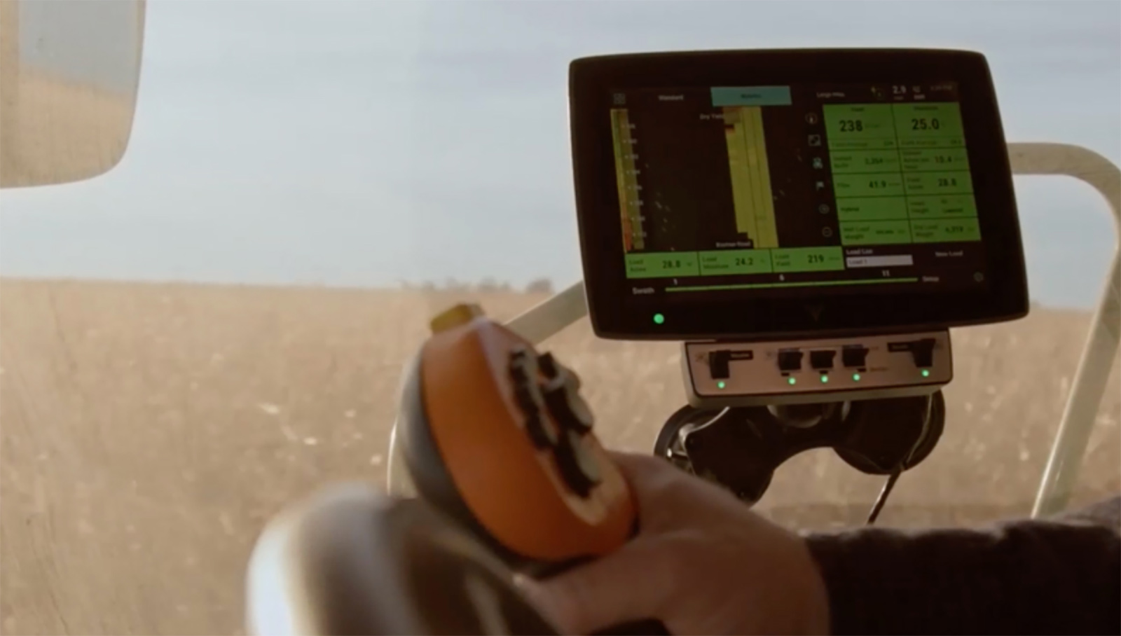 a farmer in the cab of the combine looking at a monitor