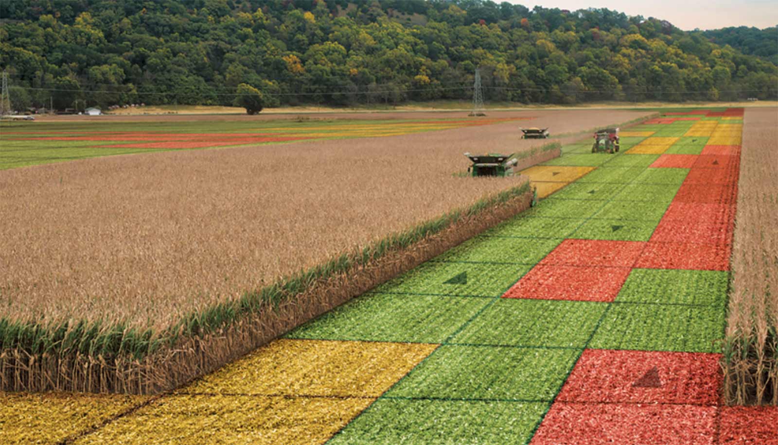 a combine in a corn field showing colored grids on harvested areas