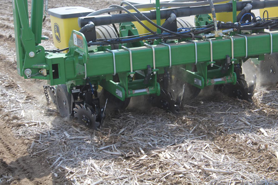 Yetter Equipment Air Adjust Series row cleaners shown on a planter in the field