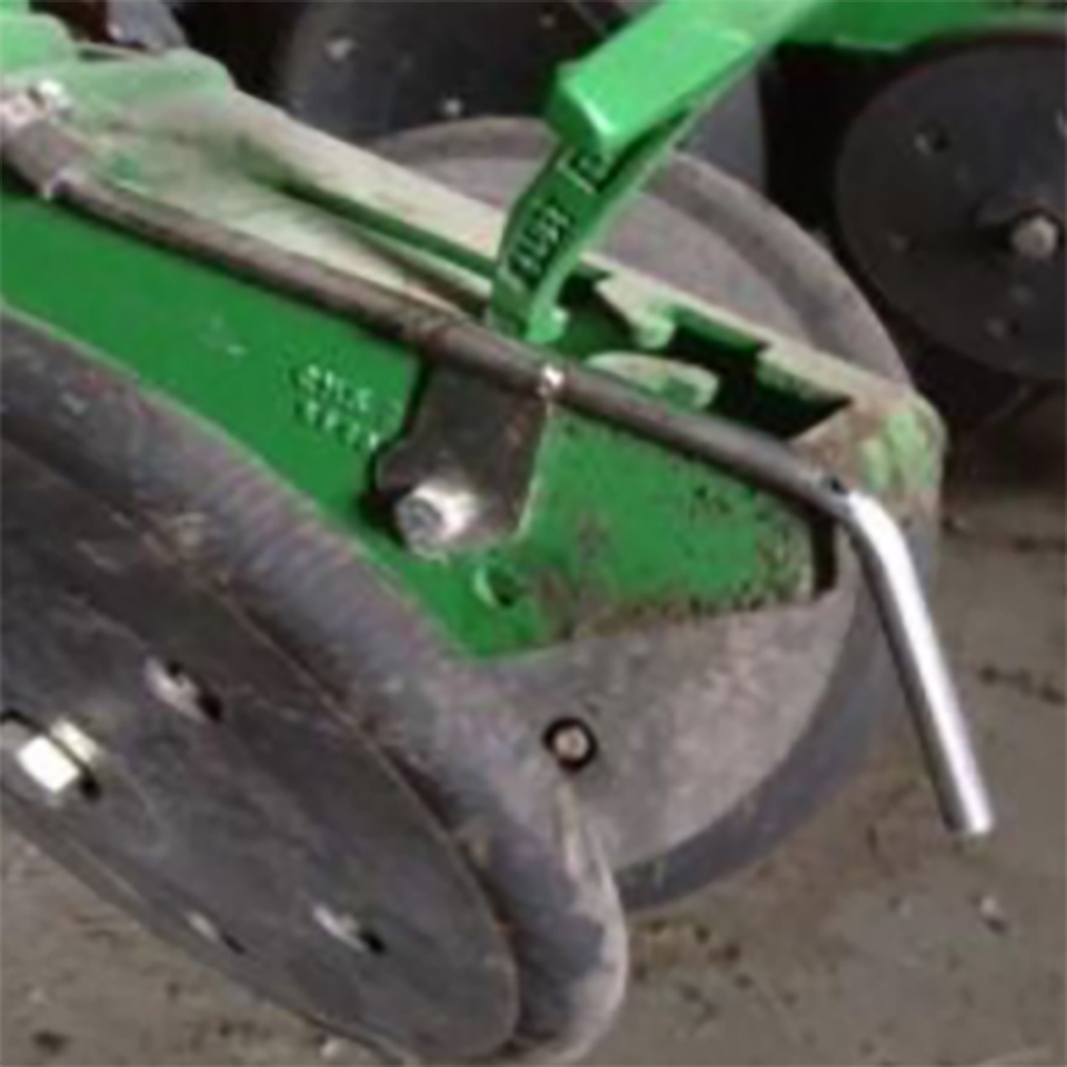 rear view of a John Deere planter row unit with fertilizer tubes installed