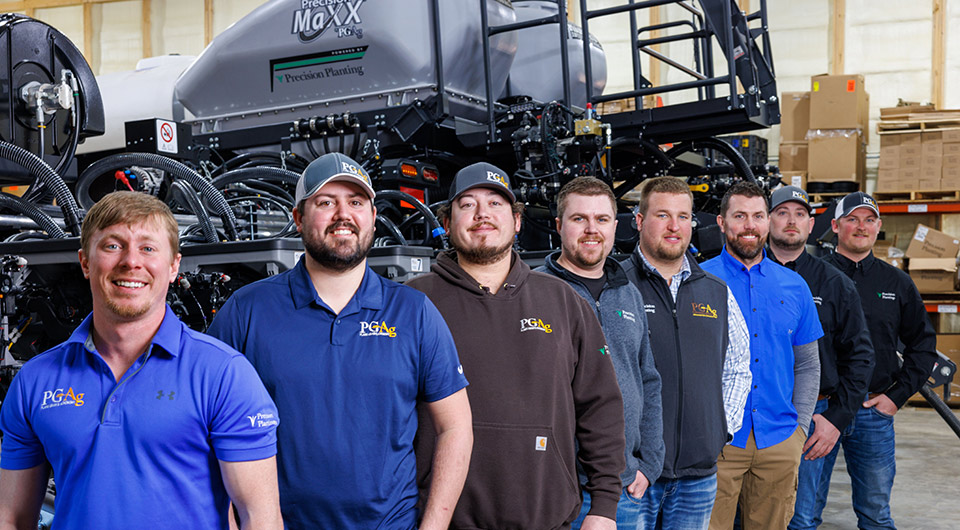 the Precision Maxx team standing behind a planter in the shop